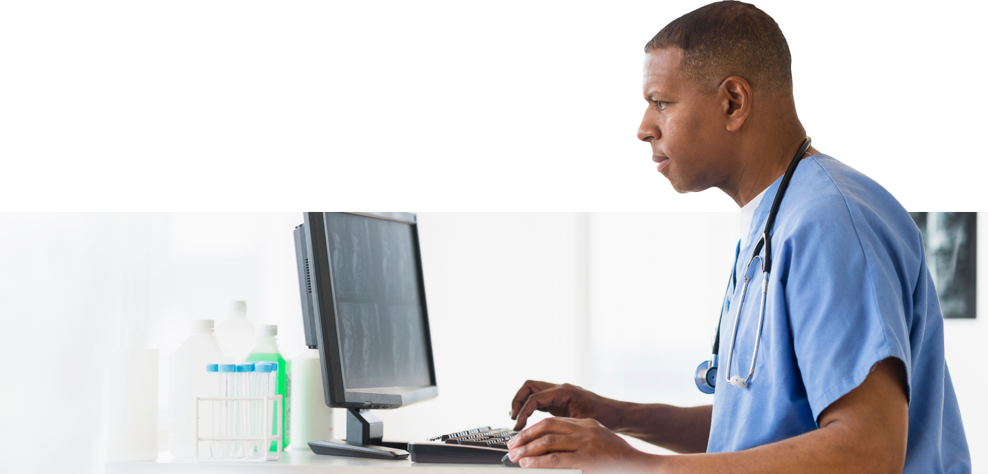 Close-up of a medical professional working at a computer.