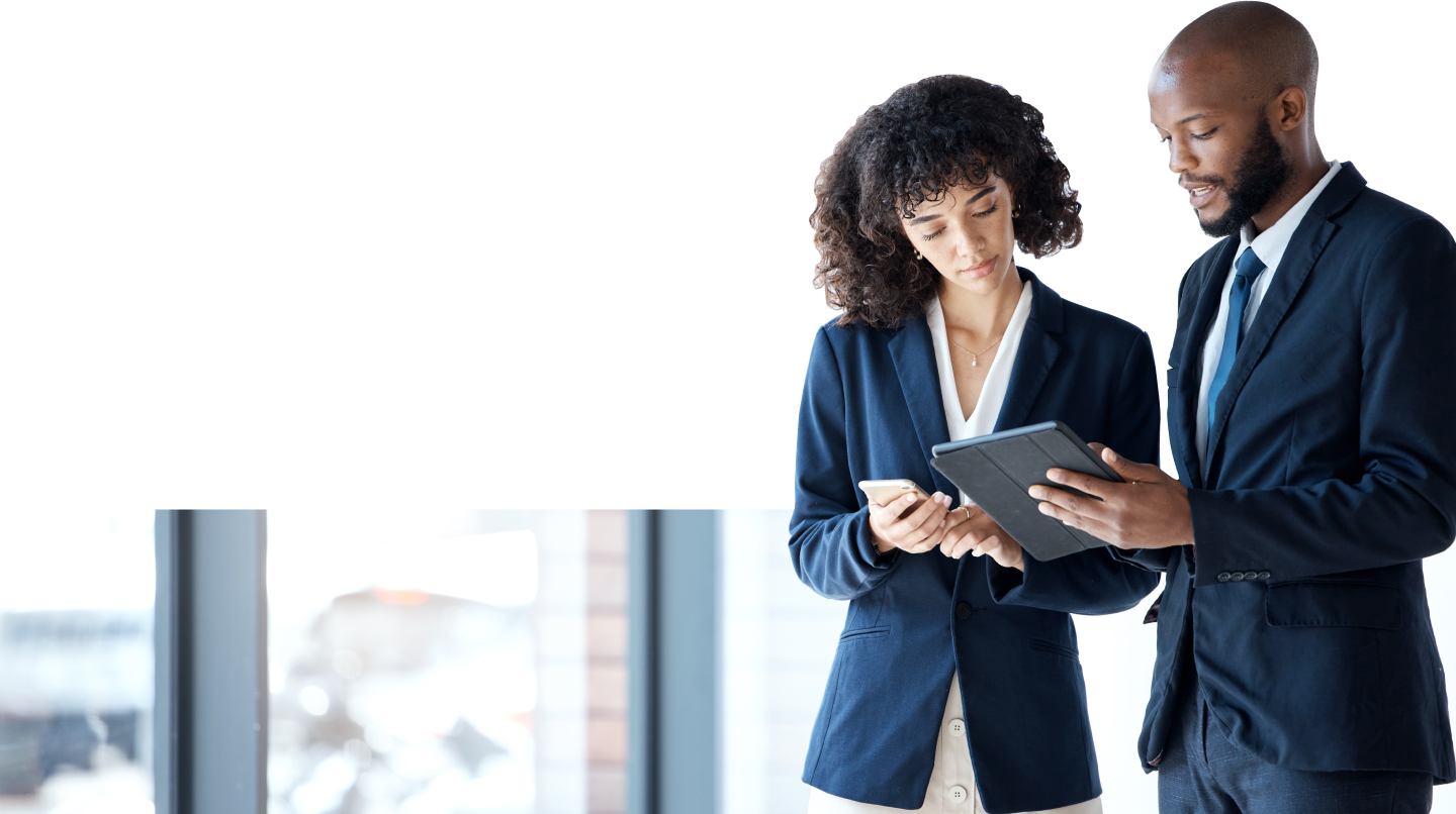 Leader standing next to a coworker who is looking at a tablet.